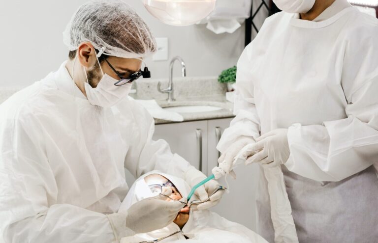 Dokter gigi sedang melakukan tindakan operasi gigi bungsu akibat impaksi